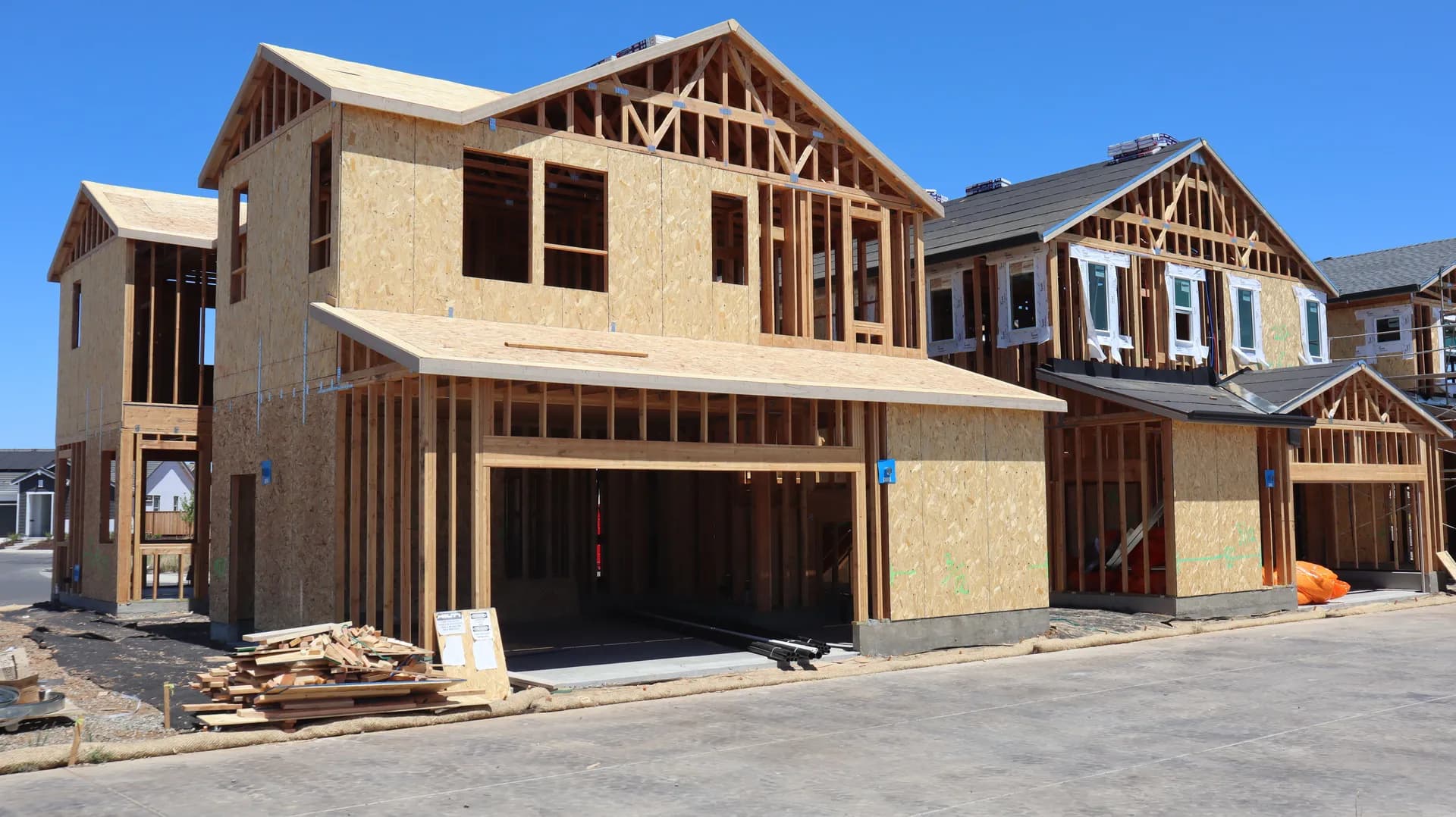 A two-story house under construction, framed but not yet finished